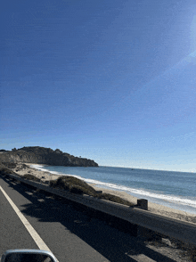 a car is driving down a highway with a view of a beach