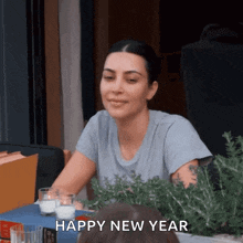 a woman is sitting at a table with a glass of milk and the words happy new year above her