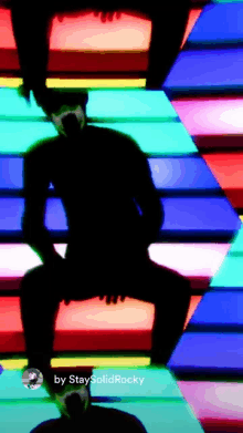 a silhouette of a man dancing in front of a colorful background with the name staysolidrocky on the bottom right