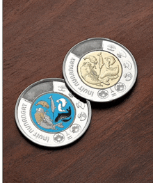 two coins on a table with one that says ' nuit nunavut '