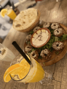 a glass of orange juice sits on a table next to a plate of food