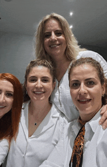 a group of women are posing for a picture and one of them has a leopard print scarf around her neck