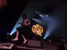 a blurry picture of a person on a stage with a yellow shirt that says ' a ' on it