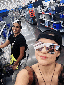 a woman wearing sunglasses takes a picture of herself in a store aisle