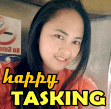 a woman is smiling in front of a no smoking sign