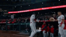 a baseball player throws a hat in the air in front of a sign that says " hitting for chicken "