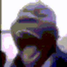 a pixelated image of a man wearing a baseball cap covering his face .