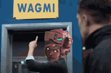 a man stands in front of a sign that says wagmi on it