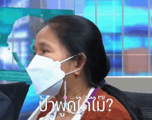 a woman wearing a face mask with the words " ปาก พูด ได้ ไหม " below her