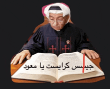 a man is sitting at a table reading a bible in arabic