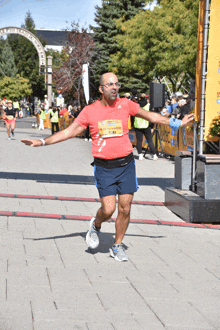 a man in a red shirt with a yellow number on it is running