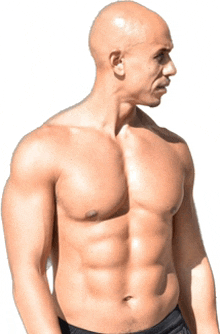 a shirtless man is standing in front of a white backdrop