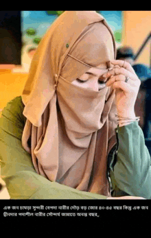 a woman wearing a hijab is covering her face