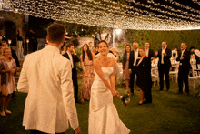 a bride and groom are dancing under a ceiling of lights