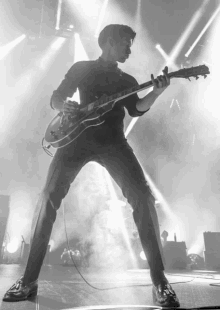 a man in a suit is playing a guitar on a stage