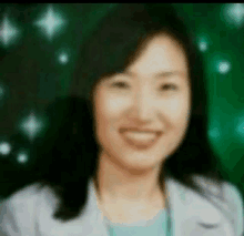 a blurry picture of a woman smiling with a green background behind her .