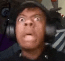 a man is wearing headphones and making a funny face .