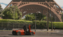 a red sports car is driving under the eiffel tower in a video game