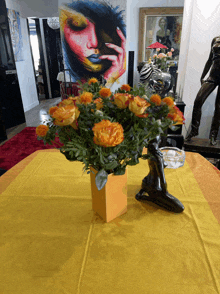 a vase of flowers sits on a table with a yellow table cloth