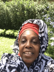 a woman wearing a scarf with the letter g on it smiles for the camera