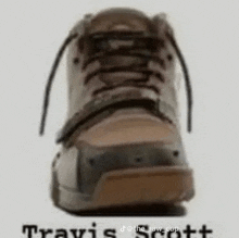 a close up of a brown shoe with the words travis scott written below it