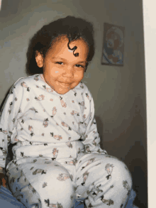 a little girl wearing pajamas with animals on them