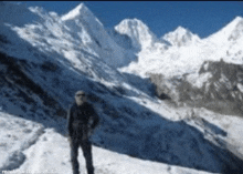 a man is standing in front of a snowy mountain