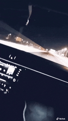 a car is driving down a highway at night and a tiktok video is shown