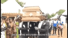 a group of men are carrying a coffin with the words `` died in the western hockey league '' on it .