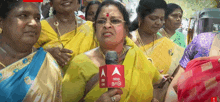 a woman is holding a microphone with abp on it