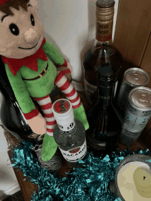 a bottle of bacardi sits next to a stuffed elf on a table