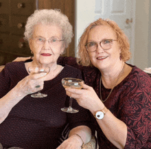 two women toasting with wine glasses one wearing a watch