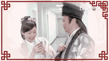 a man and a woman are standing next to each other in a hallway with tvb.com written on the corner