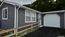 a gray house with a white garage door and a onekey mls logo