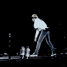 a man in a hard hat is standing on a stage holding a bottle of water .