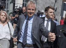 a man in a suit and tie is holding hands with a woman