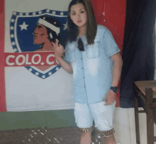 a woman stands in front of a flag that says colo.c on it