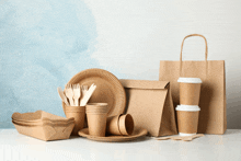 a table topped with paper plates cups and a bag