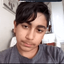 a young boy taking a selfie with a computer screen in the background