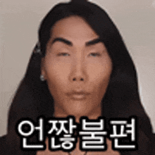 a woman with long hair is making a funny face with korean writing on it .