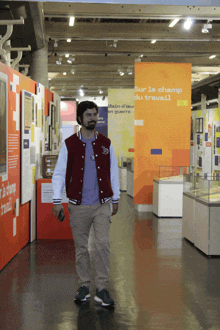 a man walks through a museum with a sign that says sur le champ du travail on it