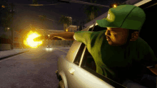 a man in a green hat with the letter s on it is pointing a gun out of a car window