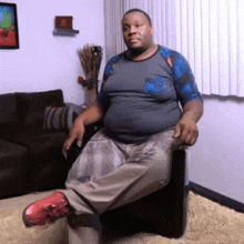 a man is sitting in a chair in a living room