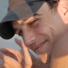 a close up of a man wearing a baseball cap .