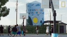 a group of young men playing basketball in front of a mural that says " you have found lost hills "