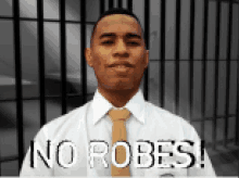 a man in a white shirt and tie stands in front of a prison cell with the words no robes