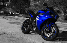 a blue and black yamaha motorcycle is parked on the side of the road