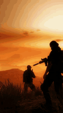 two soldiers are silhouetted against a sunset in the desert