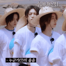 a group of young men wearing straw hats and white shirts are standing next to each other on a beach