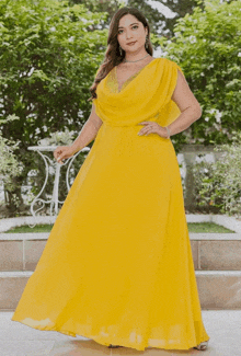 a woman is wearing a yellow dress with a plunging neckline